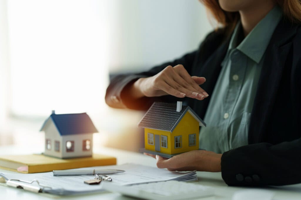 a woman holding and checking house model .real estate house appraisal and inspection and insurance concept.