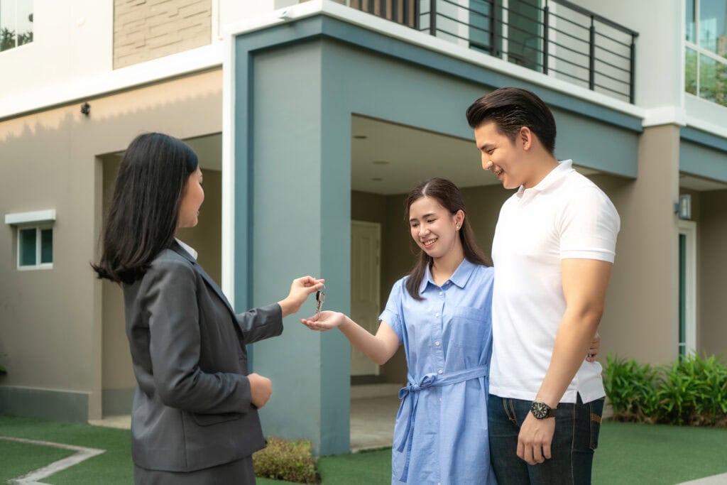 asian happy smile young couple take keys new big house from real
