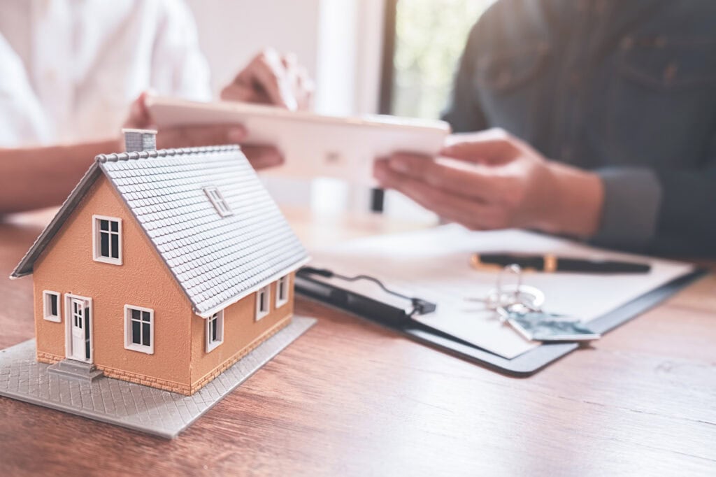 car and house model with agent and customer discussing for contr